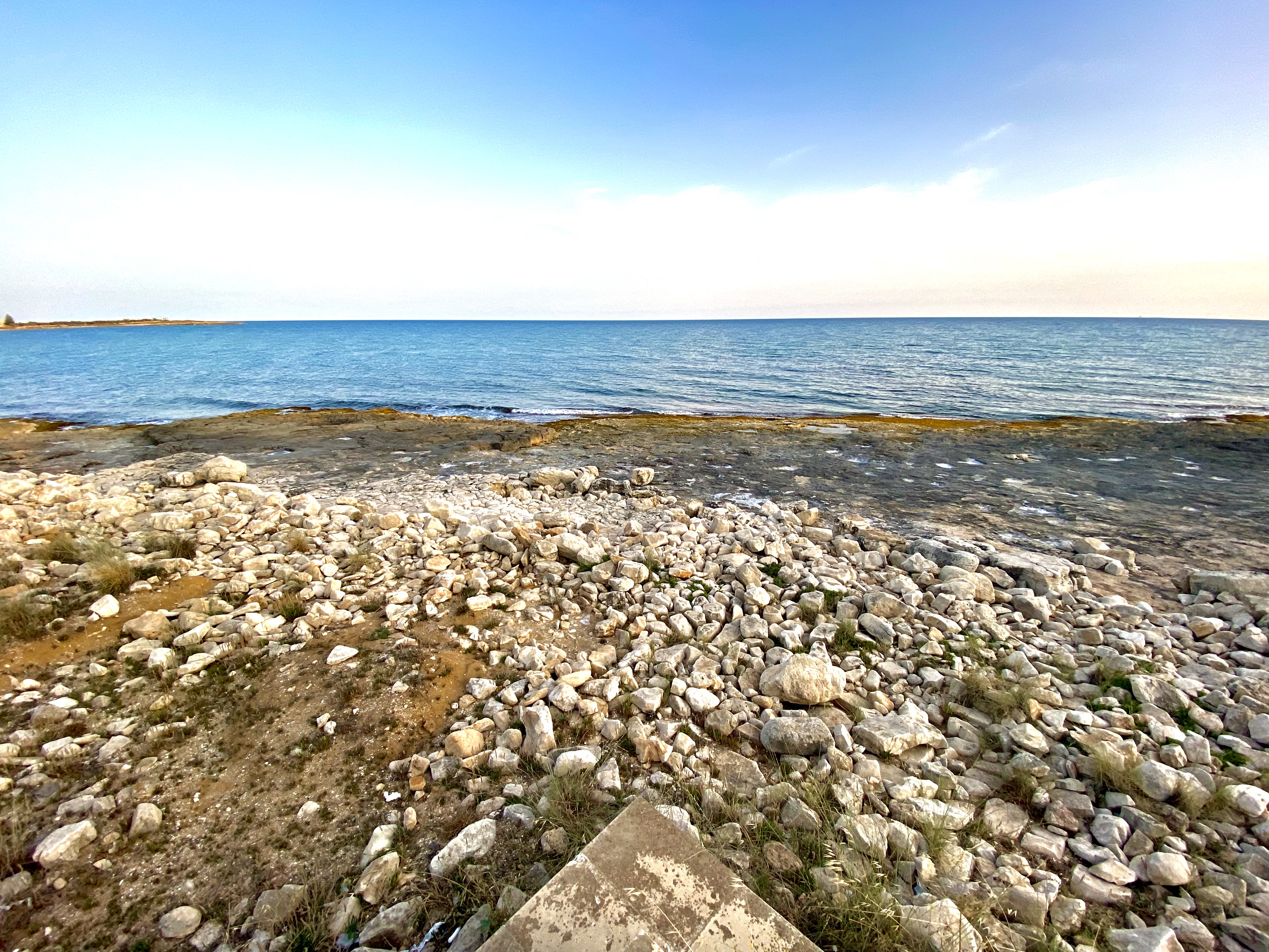 Scogliera calcarea piatta di Marina di Modica con mare calmo e azzurro
