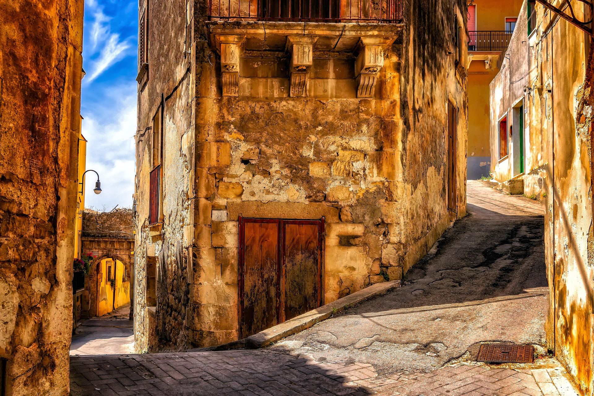 Vicoli in pietra calcarea di Modica — case antiche, portali barocchi e scorci sulla città vecchia